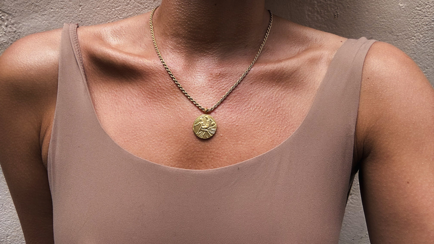 18k gold pendant necklace featuring a coin design